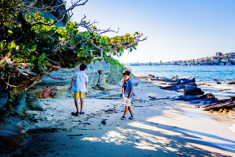 two young boys exploring a secluded beach