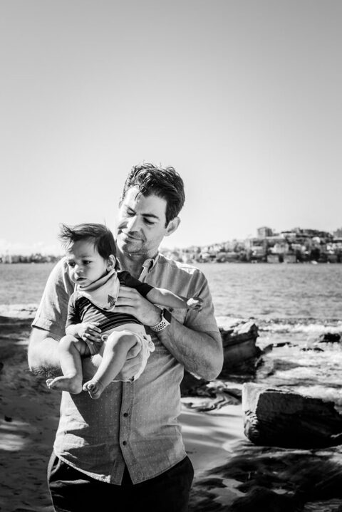 A father holding his son in his arms by Sydney Harbour